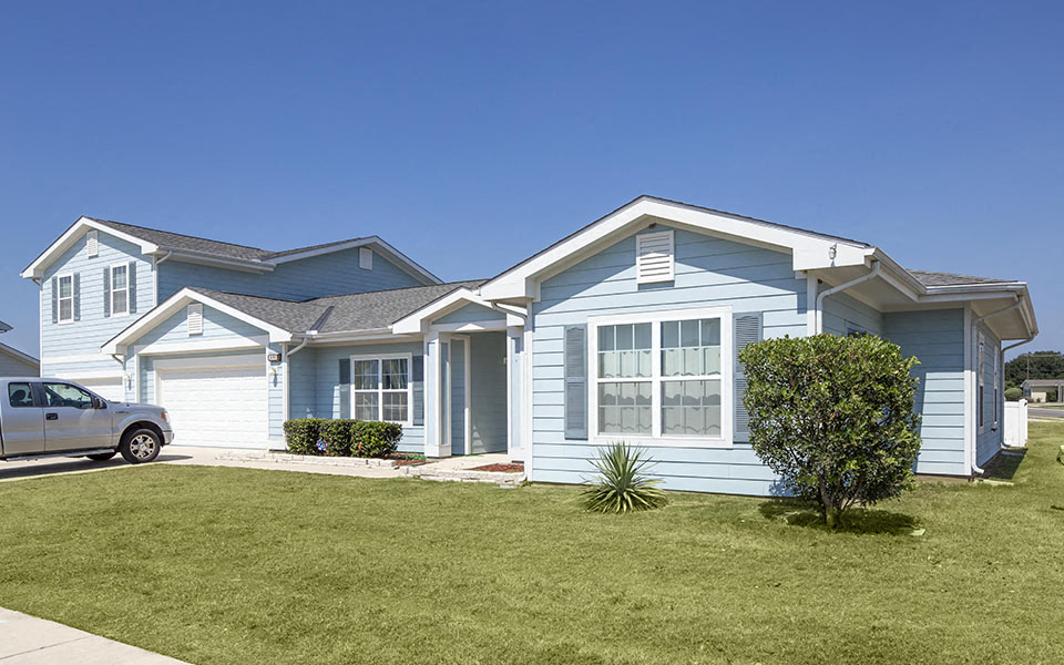 a blue house with a car parked in front of it