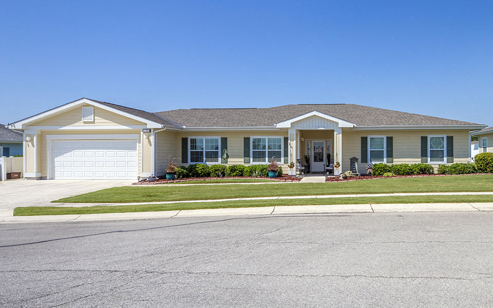 a house with a driveway and lawn in front of it