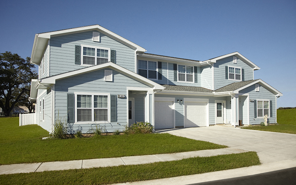 a blue house with a sidewalk in front of it