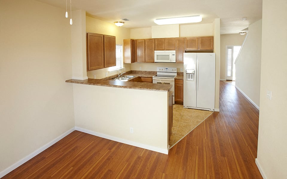 a view of a kitchen and a living room with wood floors
