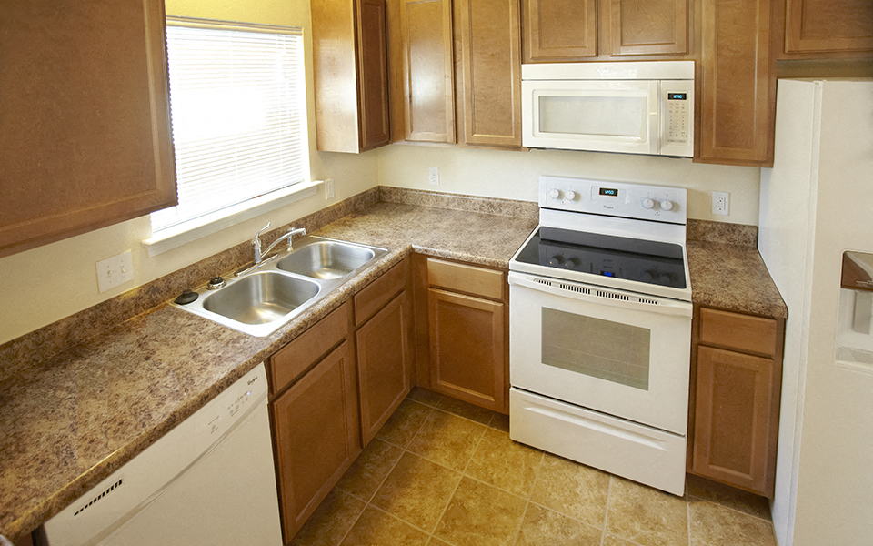 a kitchen with white appliances and granite counter tops