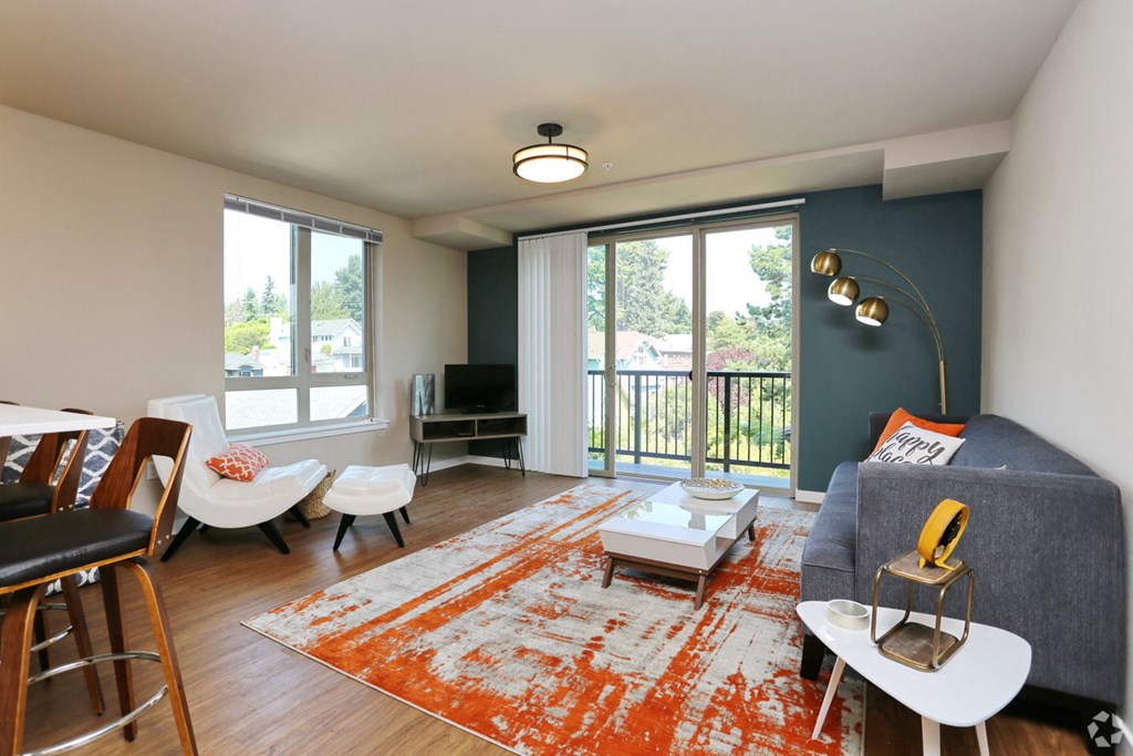 a living room with a blue accent wall and a balcony