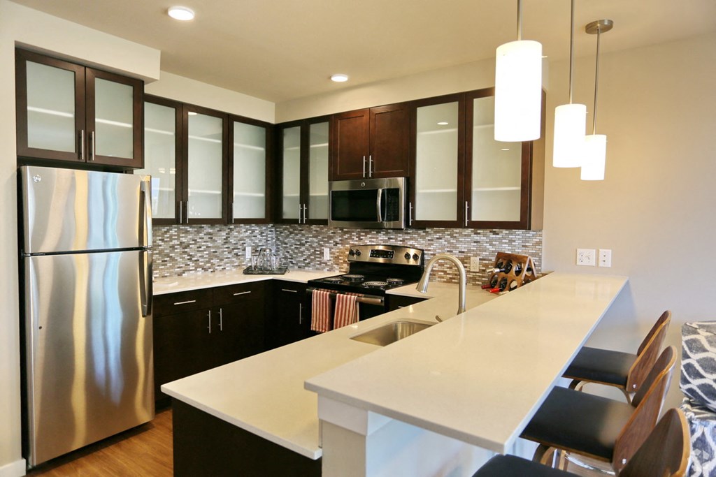 a kitchen with a large island and a stainless steel refrigerator
