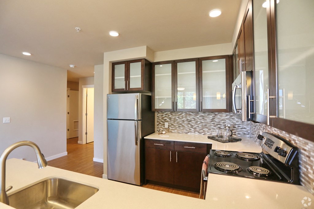 a kitchen with stainless steel appliances and white counter tops