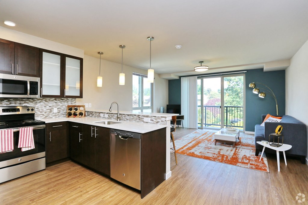 an open kitchen and living room with a view of a balcony