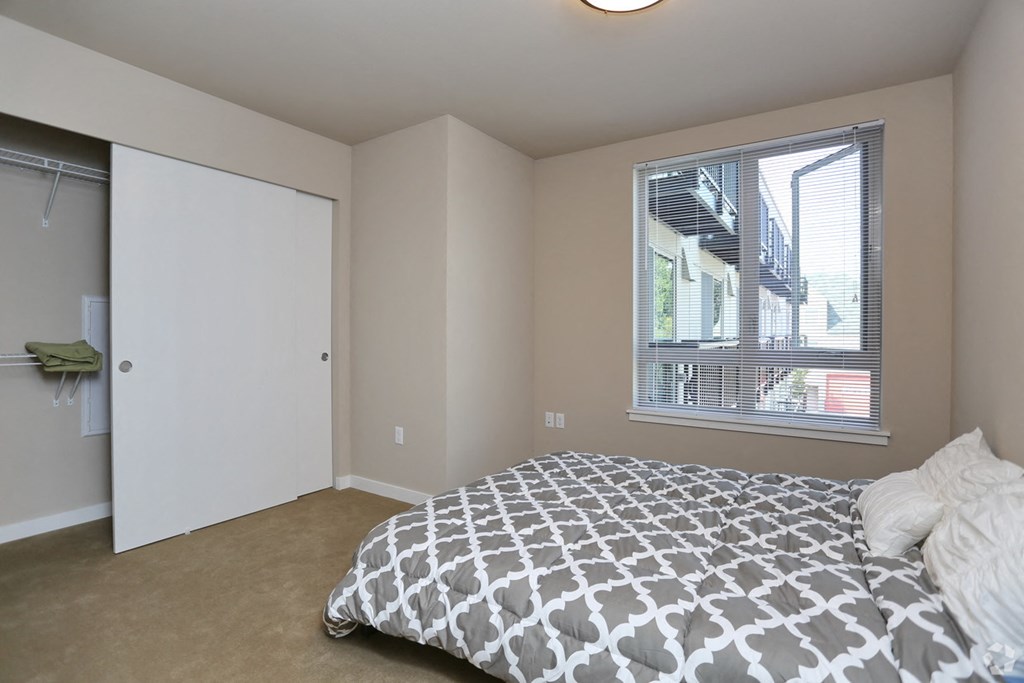 a bedroom with a bed and a closet and a window