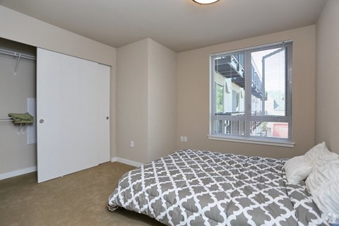 a bedroom with a bed and a closet and a window