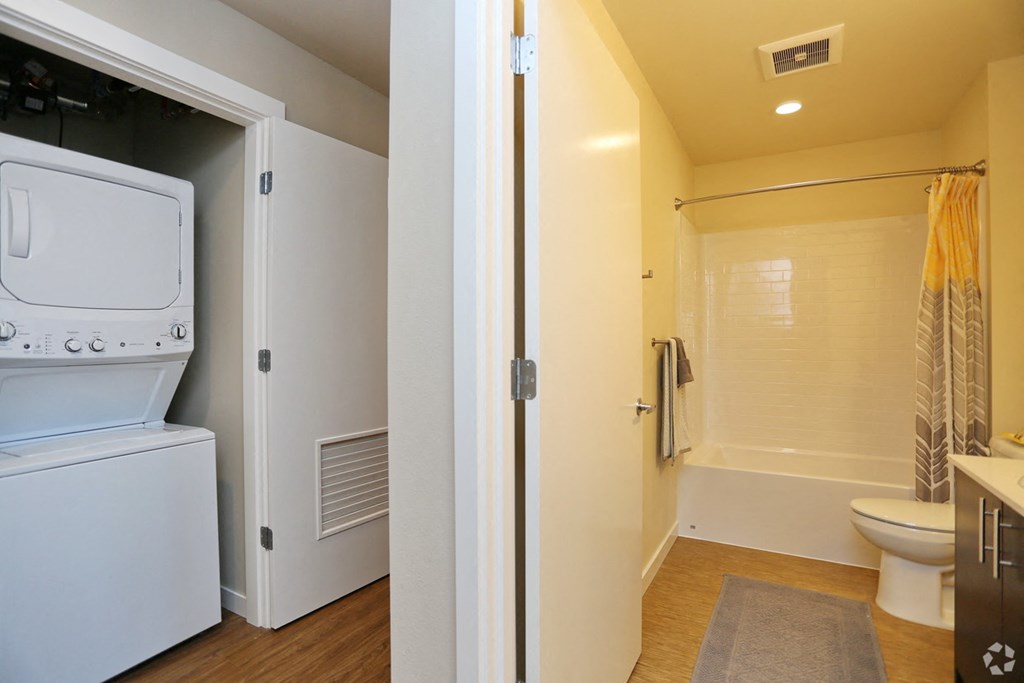 a laundry room with a washer and dryer next to a bathroom