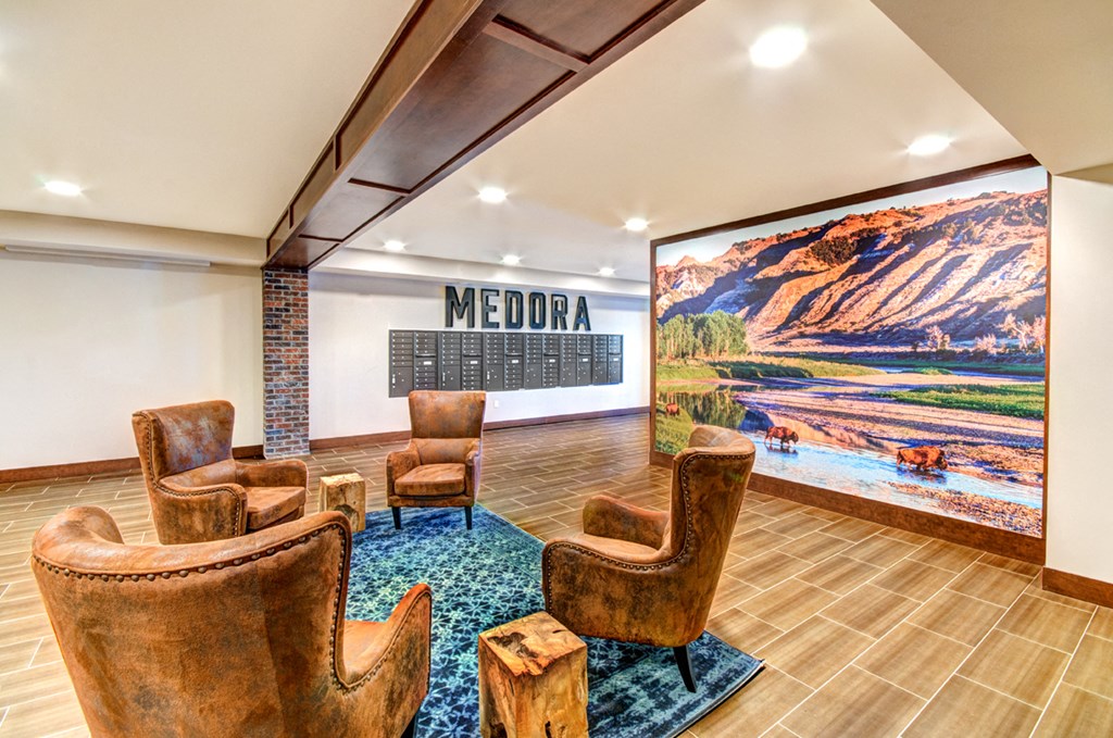 a lobby with chairs and a large mural on the wall