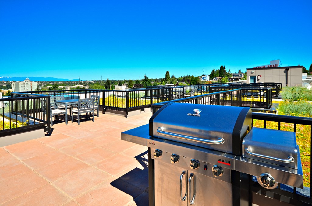 the outdoor patio has a grill and a view of the city