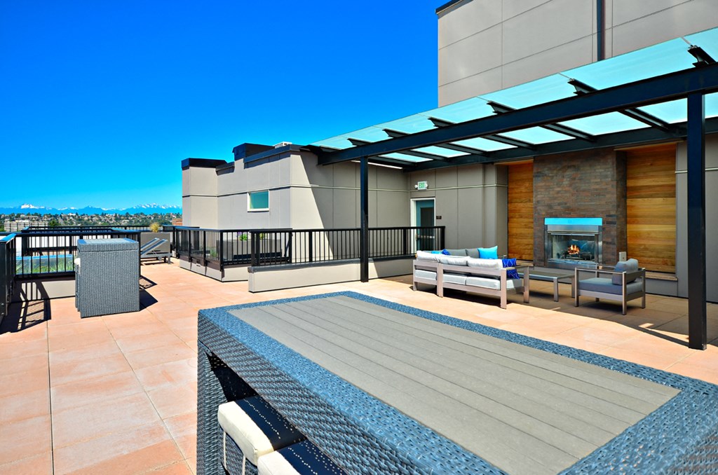 a rooftop deck with a pool and a fireplace