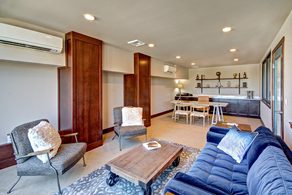 a living room with a couch and chairs and a kitchen with a table