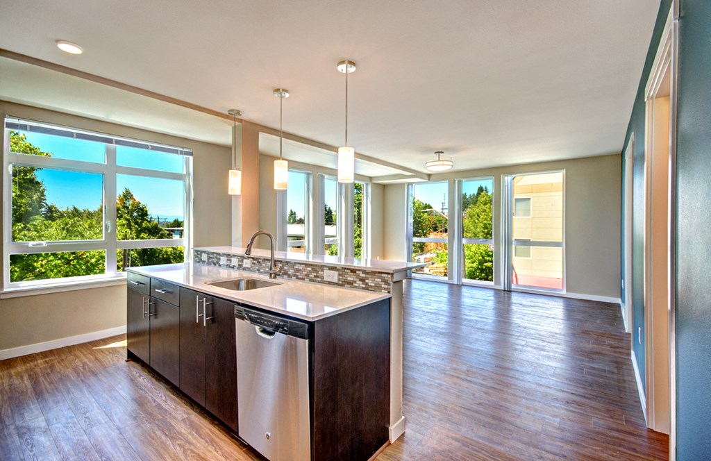 an open kitchen and living room with large windows