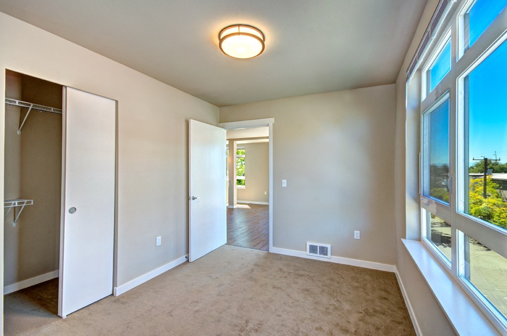 an empty room with a large window and a closet