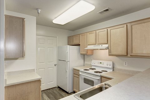 a kitchen with white appliances and wooden cabinets