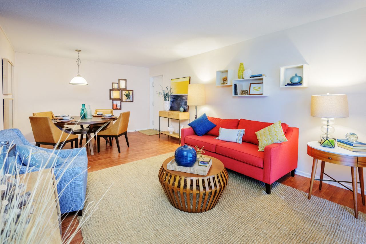 a living room with a red couch and a dining room table