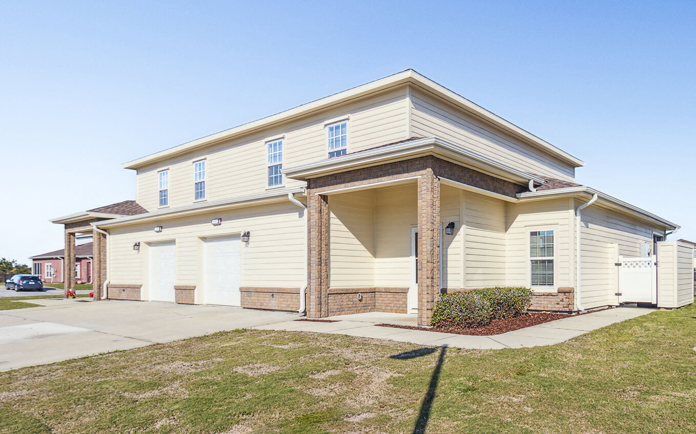 a yellow house with a sidewalk in front of it