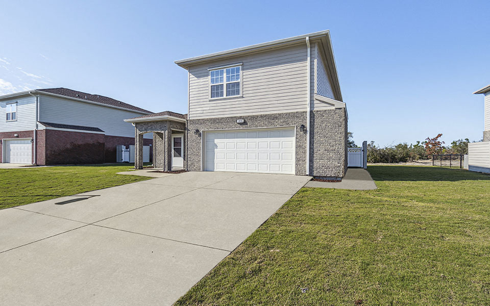 a white house with a white garage door and a driveway