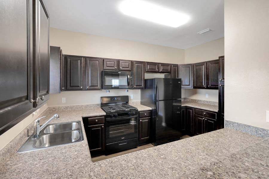 a kitchen with black appliances and granite counter tops
