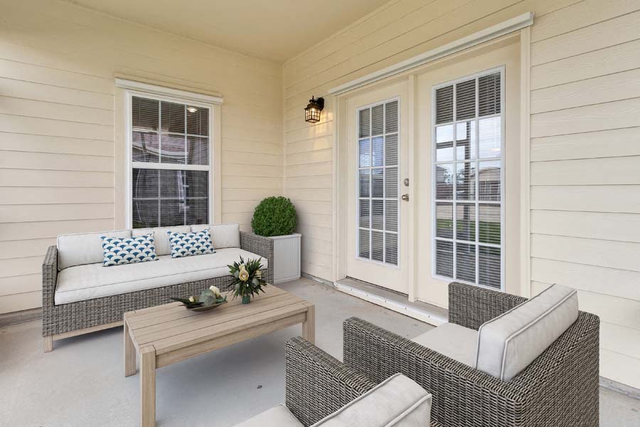 a porch with a couch and chairs and a table