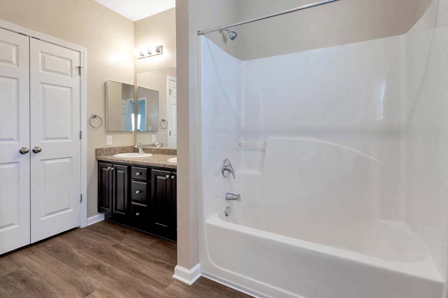 a bathroom with a tub and a sink and a mirror