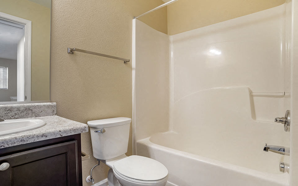 a bathroom with a toilet and a tub and a sink