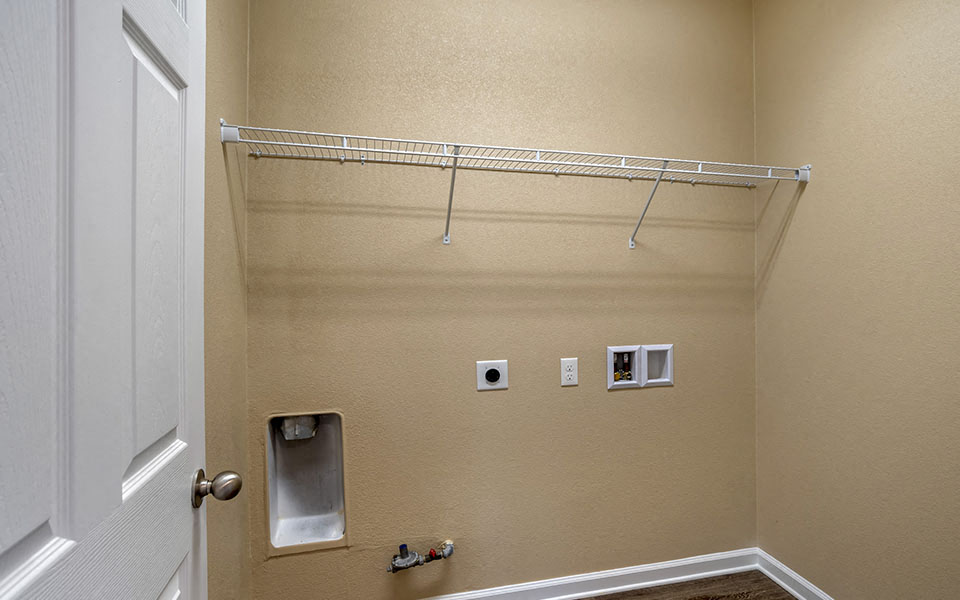 a walk in closet in a bathroom with a rack on the wall