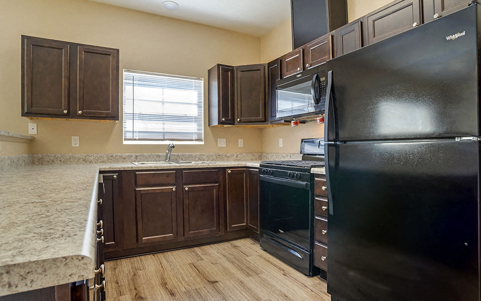 a kitchen with black appliances and brown cabinets