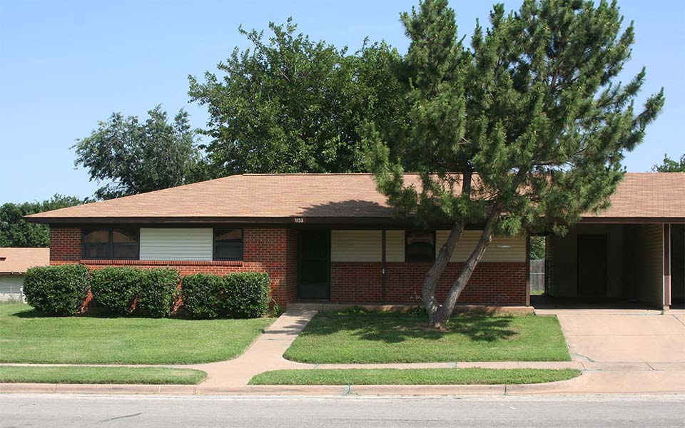 a brick house with a tree in the front