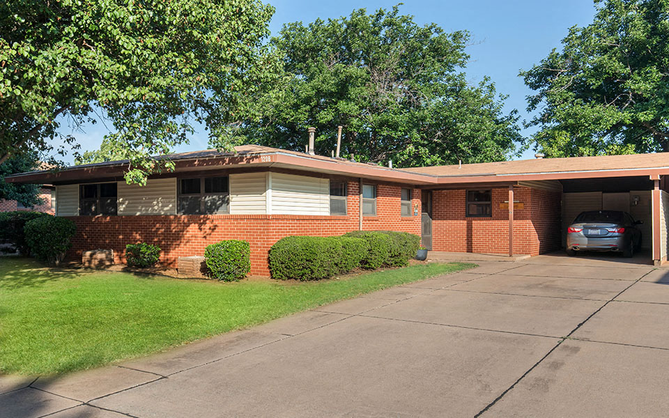 a brick house with a car parked in the driveway