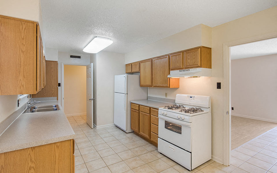 a kitchen with white appliances and wooden cabinets