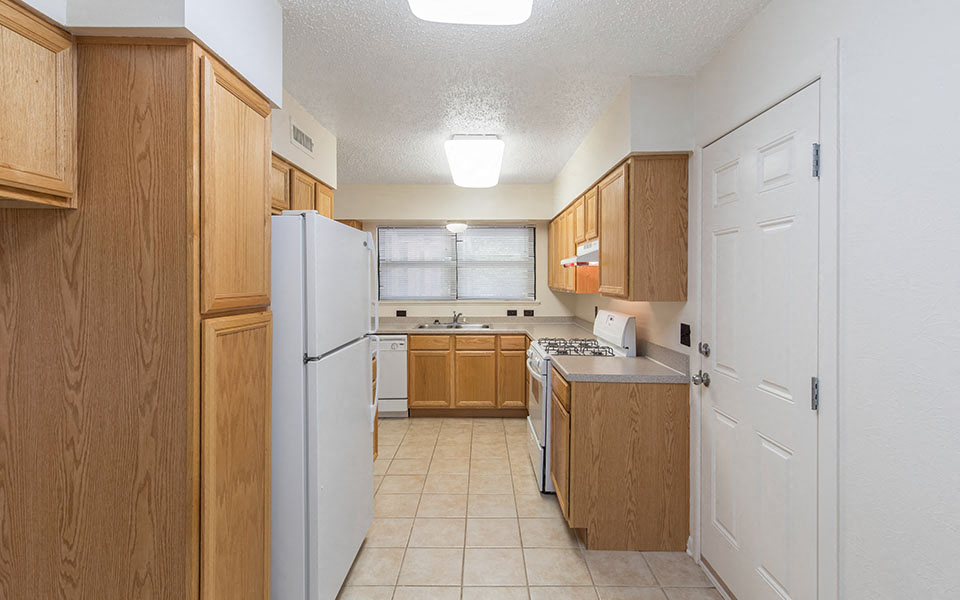 a kitchen with white appliances and wooden cabinets
