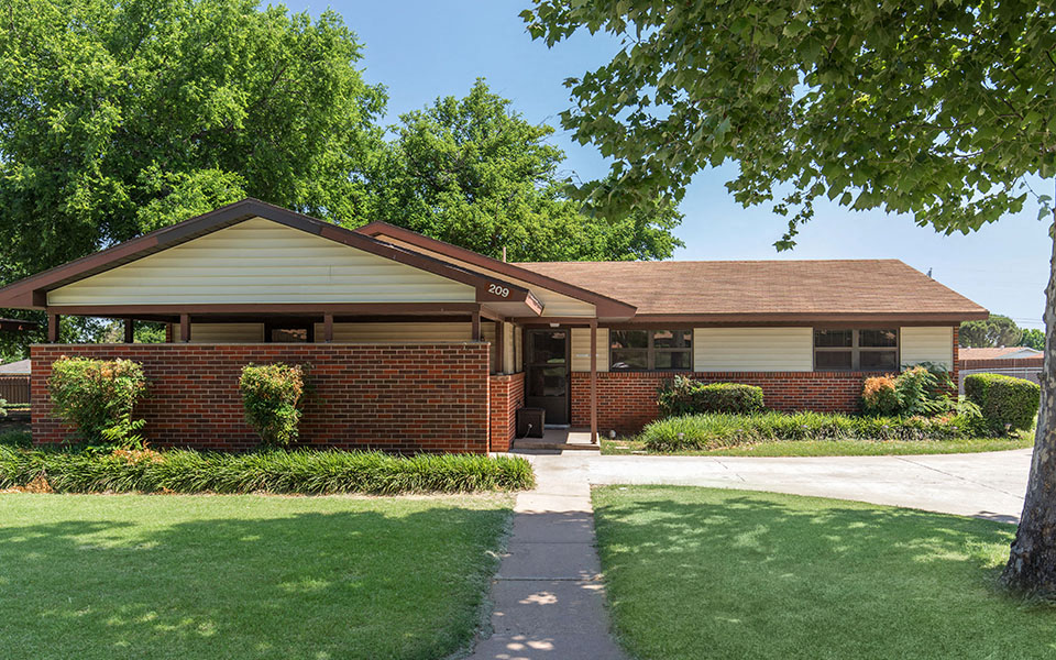 a brick house with a sidewalk in front of it