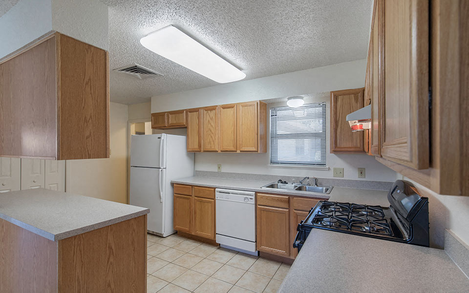 a kitchen with white appliances and wooden cabinets