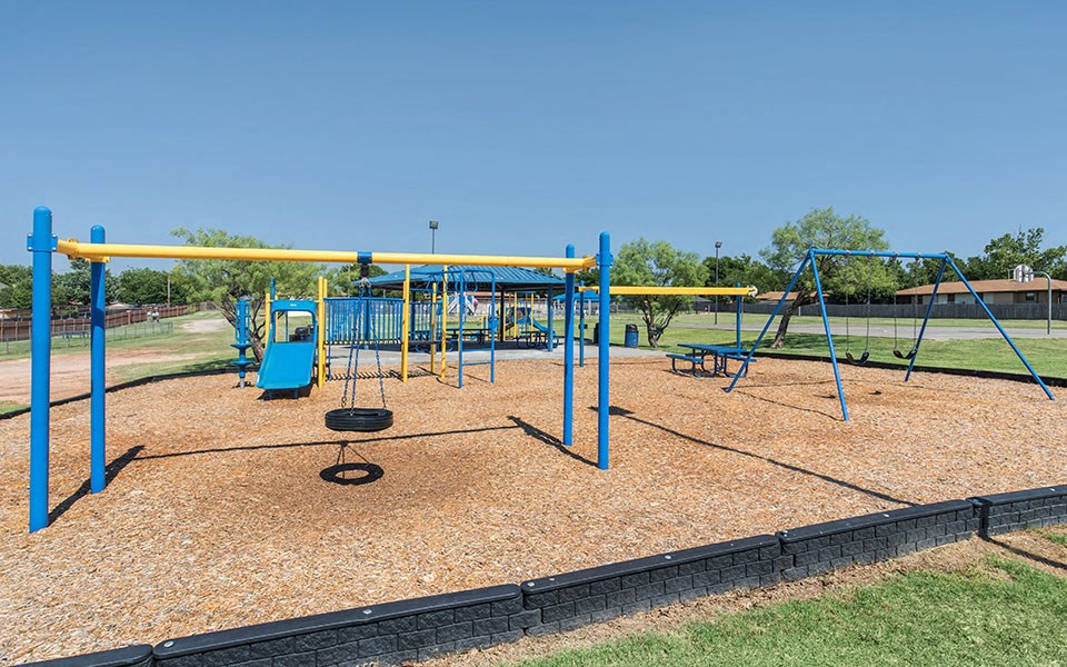 a swing set at a playground on a clear day