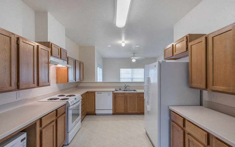 a kitchen with white appliances and wooden cabinets