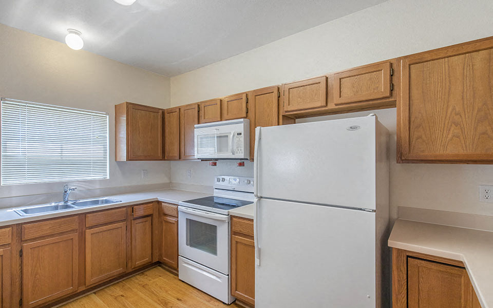 a kitchen with white appliances and wooden cabinets