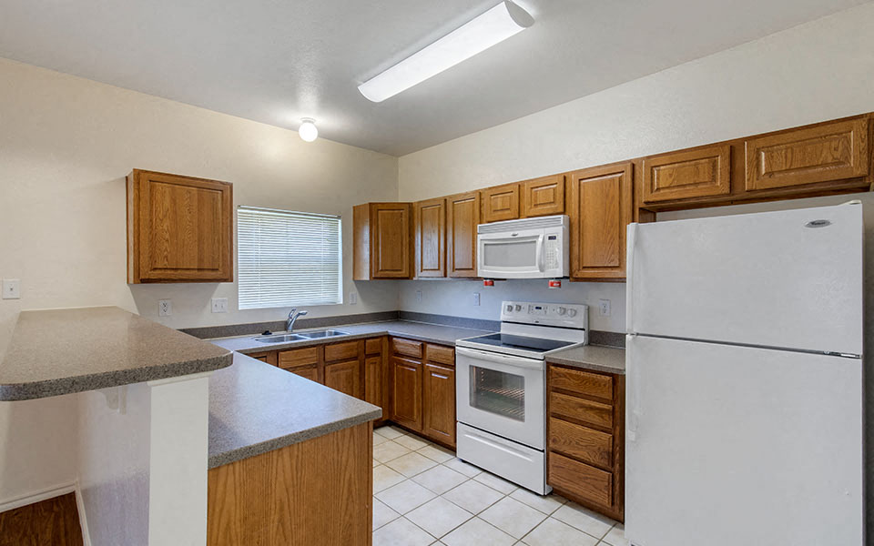 a kitchen with white appliances and wooden cabinets