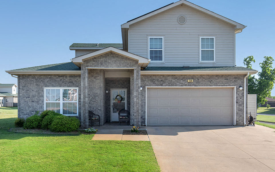 a house with a garage door and a lawn