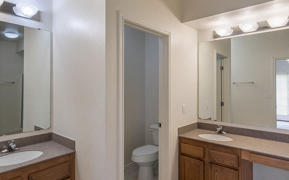 a bathroom with two sinks and a toilet and a mirror