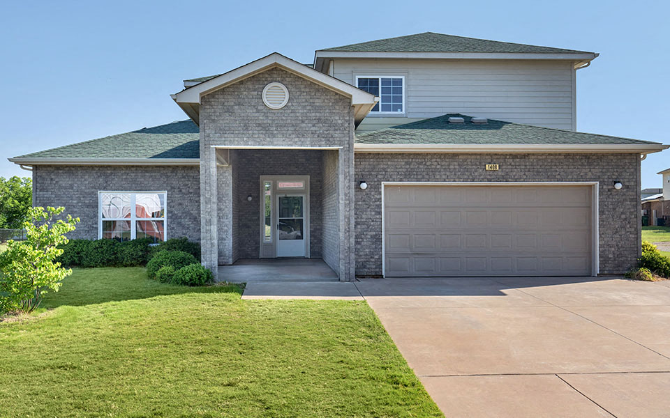 a house with a garage door and a lawn