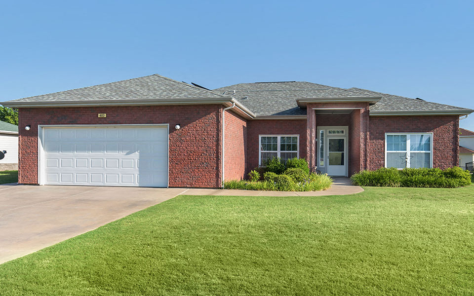 a red brick house with a white garage door