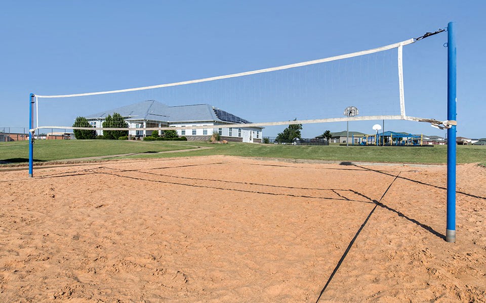 a volleyball court with a house in the background
