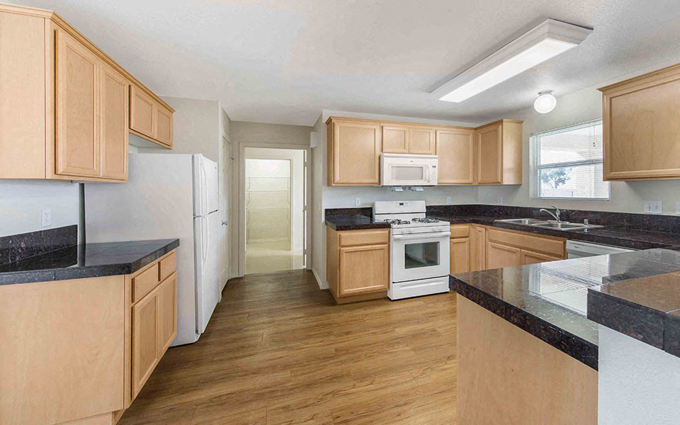 a kitchen with wooden cabinets and white appliances
