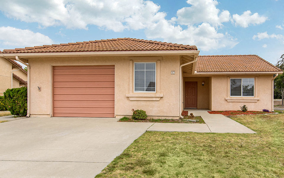 a pink house with a driveway and a garage door