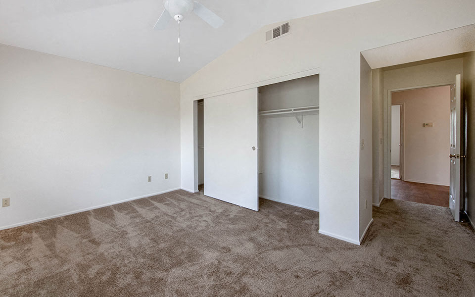 an empty living room with white walls and a closet