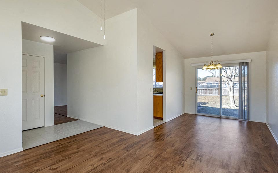 an empty living room with a door to a patio