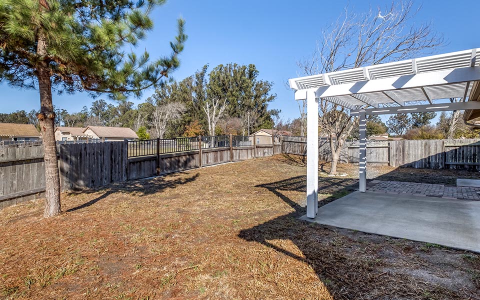 a backyard with a picnic area and a white pavilion