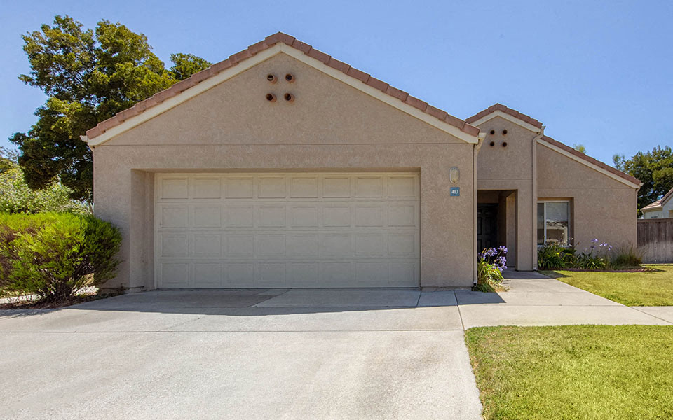 a tan house with a white garage door