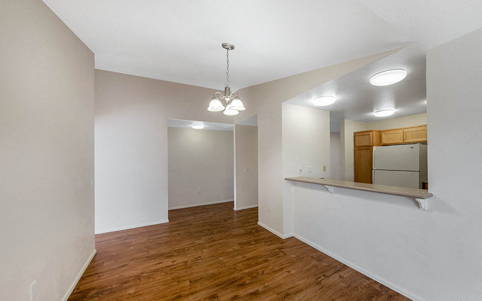 a renovated living room with a kitchen and a hard wood floor